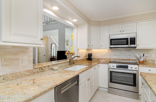 kitchen featuring white cabinets, appliances with stainless steel finishes, sink, light tile patterned flooring, and crown molding