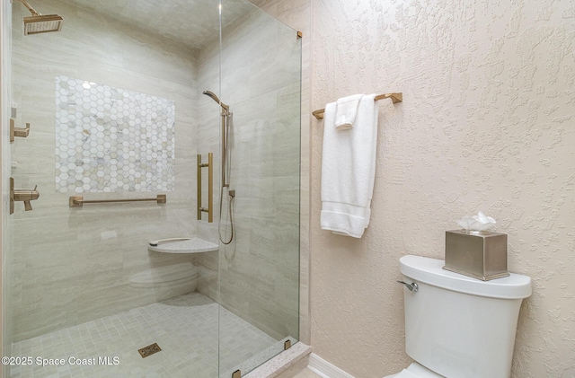 bathroom with toilet and a tile shower