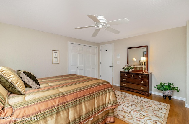 bedroom with ceiling fan, a closet, and wood-type flooring