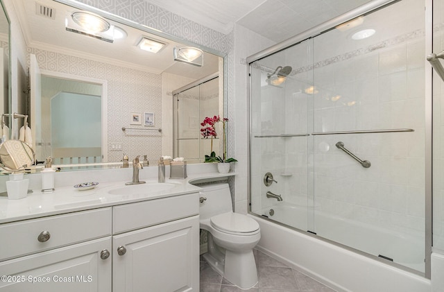 full bathroom with tile patterned flooring, vanity, toilet, combined bath / shower with glass door, and crown molding