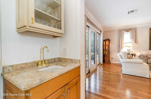 bathroom featuring vanity, crown molding, and hardwood / wood-style floors