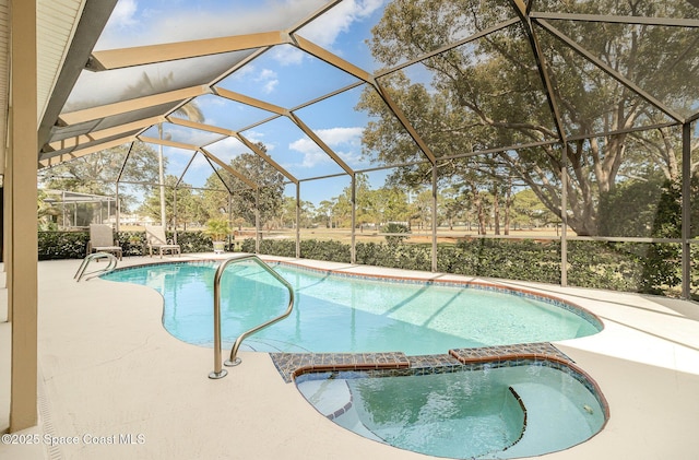 view of pool with a patio area, glass enclosure, and an in ground hot tub