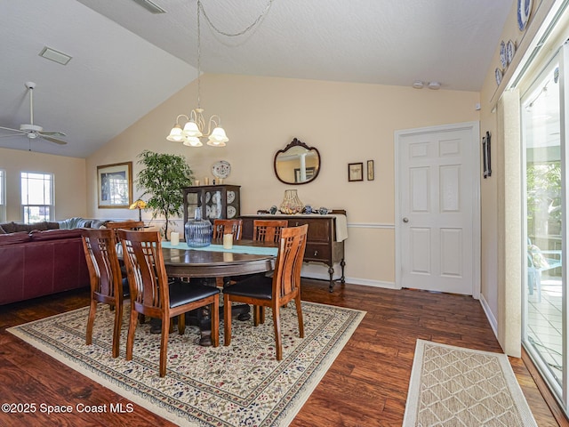 dining space with dark hardwood / wood-style flooring, ceiling fan with notable chandelier, lofted ceiling, and a textured ceiling