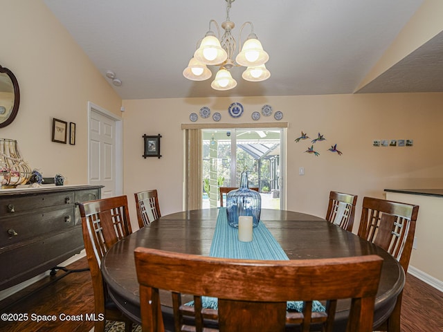 dining room with dark hardwood / wood-style flooring, lofted ceiling, and a chandelier