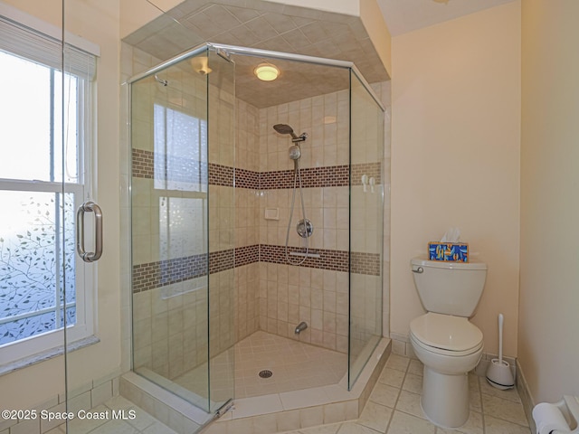 bathroom featuring toilet, an enclosed shower, and tile patterned flooring