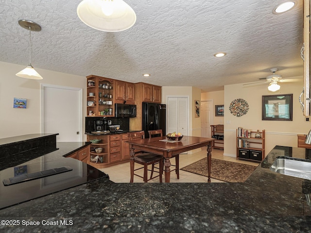 kitchen featuring decorative light fixtures, sink, a textured ceiling, and black appliances