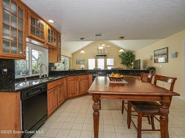 kitchen with lofted ceiling, decorative light fixtures, a textured ceiling, dishwasher, and kitchen peninsula