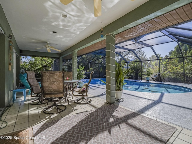 view of swimming pool with ceiling fan, a lanai, and a patio