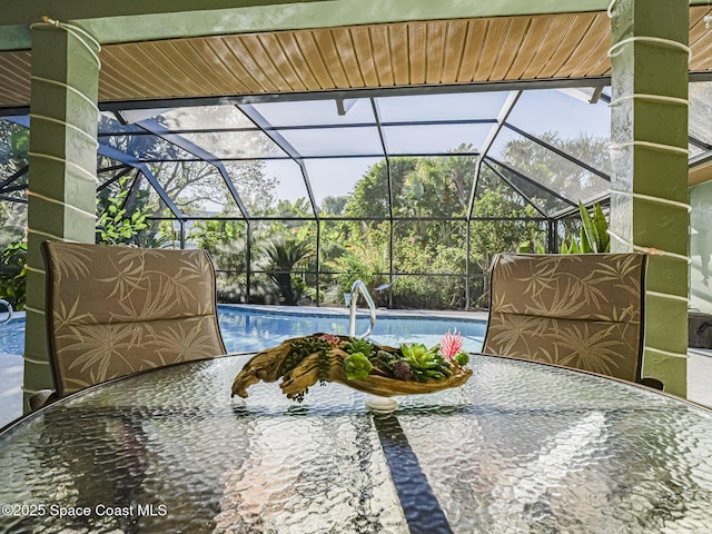 view of pool with glass enclosure and a patio area