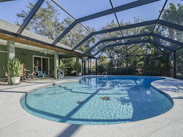 view of swimming pool featuring ceiling fan, glass enclosure, and a patio