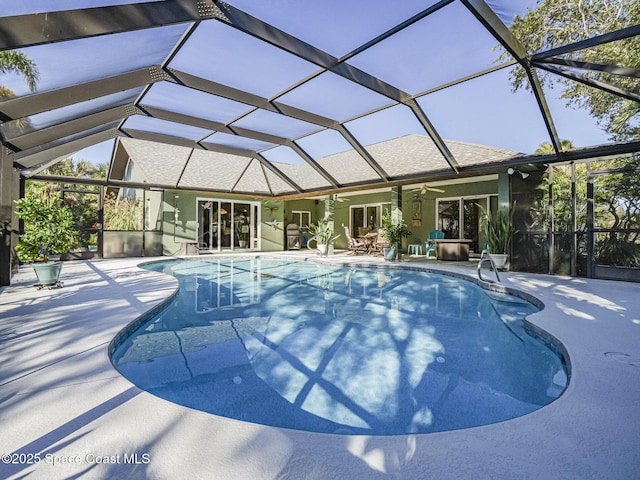 view of swimming pool featuring ceiling fan, a lanai, and a patio