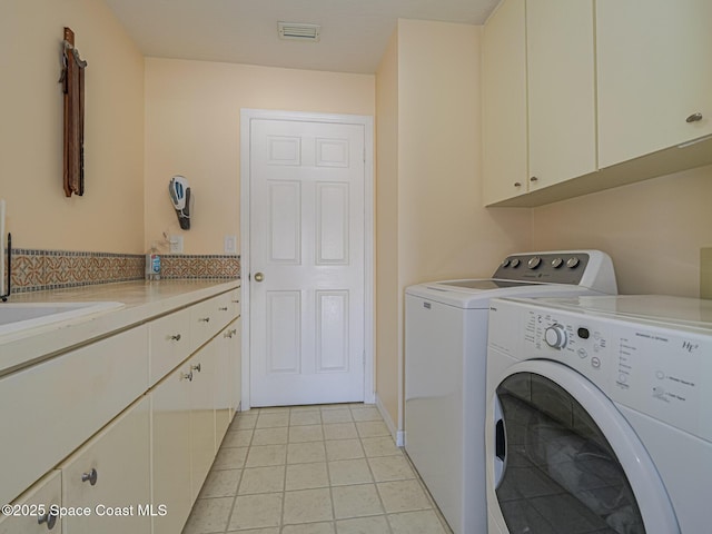 laundry area featuring cabinets, washing machine and clothes dryer, light tile patterned flooring, and sink