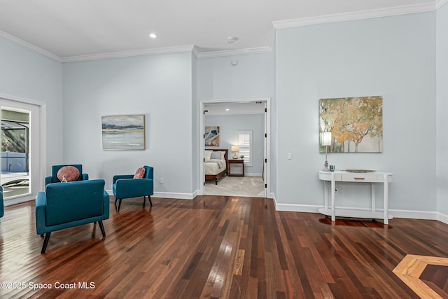 living area with baseboards, hardwood / wood-style floors, and ornamental molding