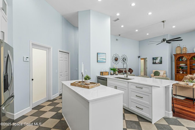 kitchen featuring tile patterned floors, a sink, appliances with stainless steel finishes, a peninsula, and light countertops