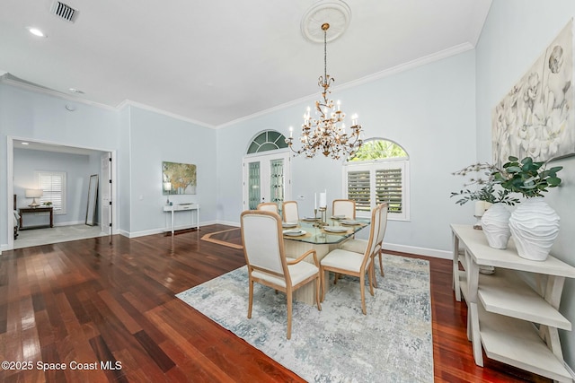 unfurnished dining area with visible vents, crown molding, baseboards, french doors, and wood finished floors