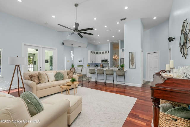 living room featuring a high ceiling, french doors, visible vents, and dark wood-style flooring