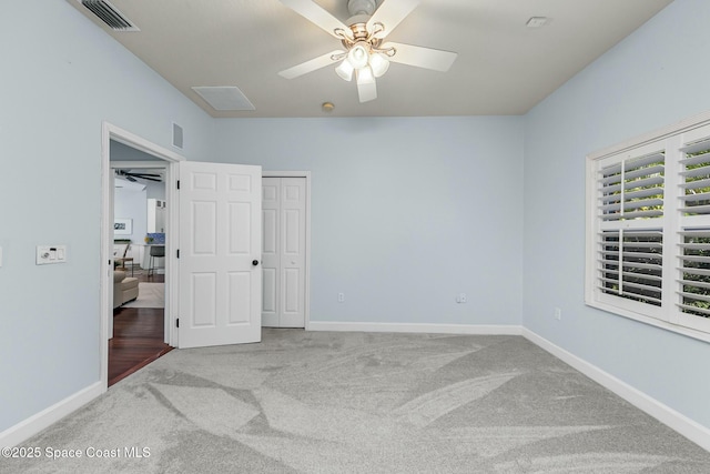 unfurnished bedroom with a ceiling fan, carpet, visible vents, and baseboards