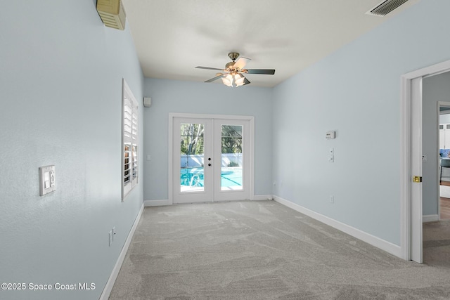 carpeted empty room with visible vents, french doors, baseboards, and ceiling fan