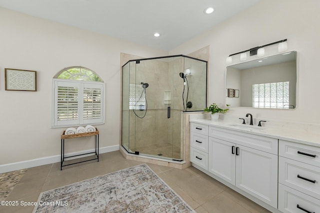 full bath with tile patterned floors, a stall shower, vanity, and baseboards