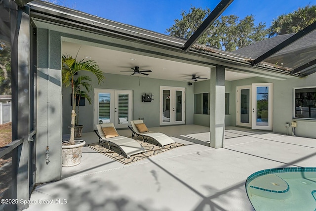 view of patio / terrace with a lanai, french doors, and ceiling fan