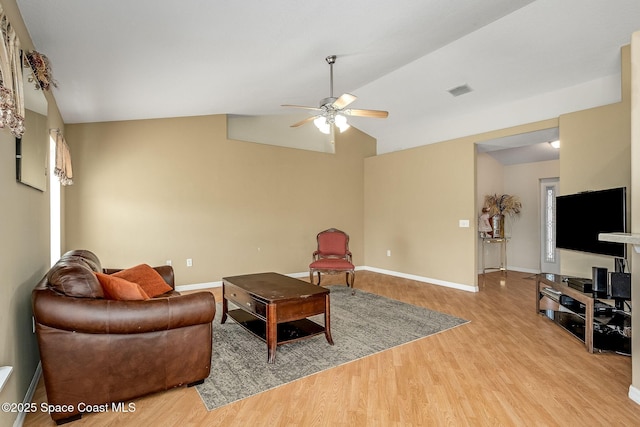 living room featuring ceiling fan, light wood-type flooring, and vaulted ceiling