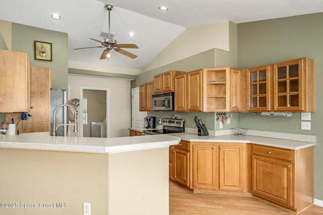 kitchen featuring light wood-type flooring, stainless steel appliances, kitchen peninsula, vaulted ceiling, and ceiling fan