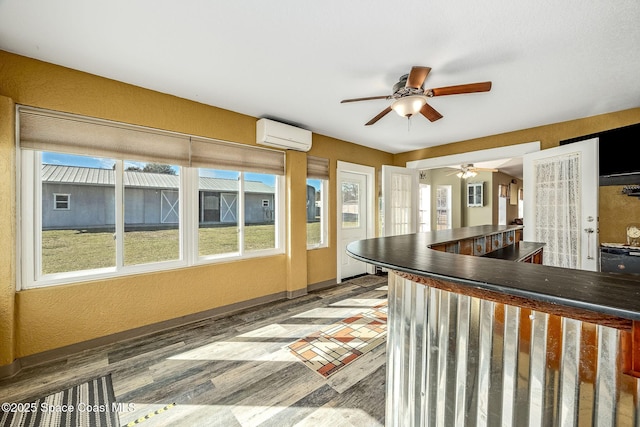 kitchen featuring ceiling fan, french doors, hardwood / wood-style flooring, and a wall mounted air conditioner