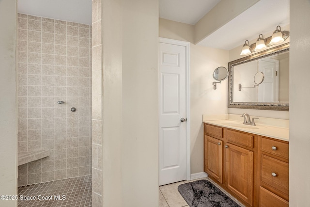 bathroom featuring vanity, tile patterned floors, and a tile shower