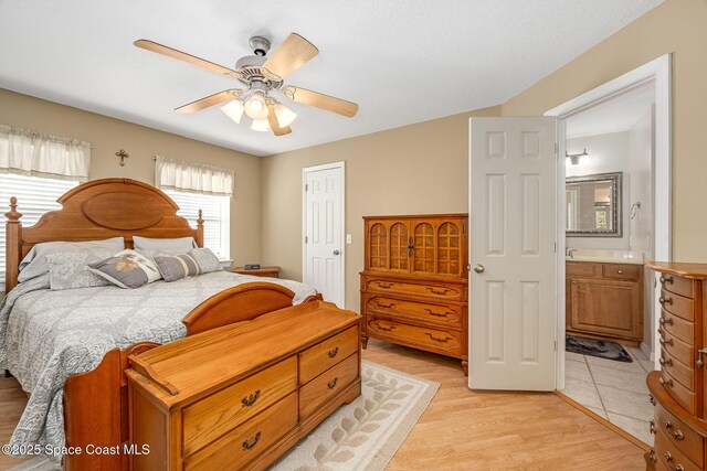 bedroom featuring ceiling fan, connected bathroom, and light hardwood / wood-style flooring