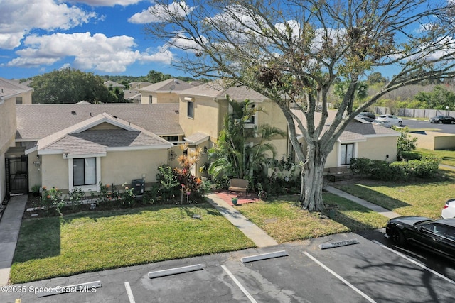 view of front of home with cooling unit and a front lawn