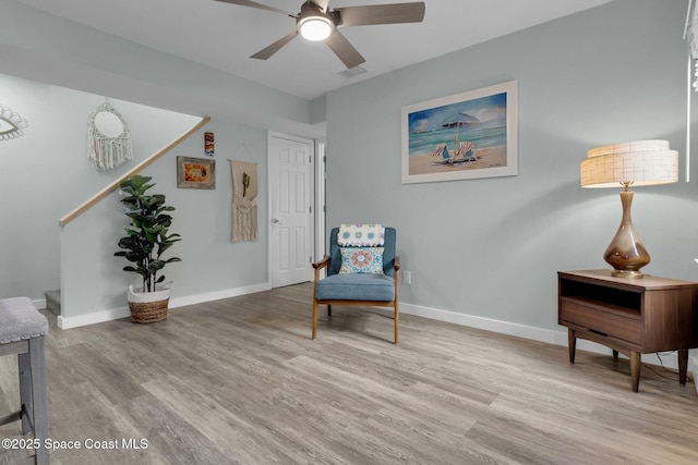 sitting room with ceiling fan and light wood-type flooring