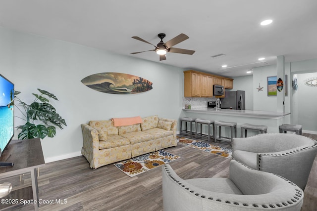 living room featuring ceiling fan, dark wood-type flooring, and sink