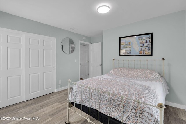 bedroom featuring hardwood / wood-style floors and a closet