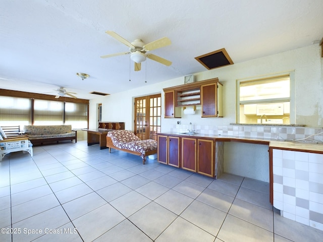 kitchen with french doors, sink, tasteful backsplash, and light tile patterned floors