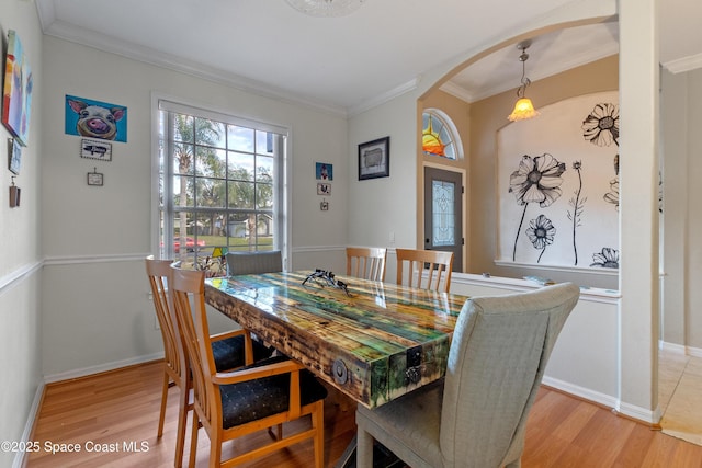 dining room featuring crown molding and light hardwood / wood-style floors