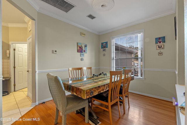 dining space featuring light tile patterned floors and ornamental molding