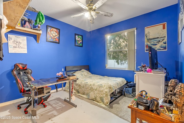 bedroom with ceiling fan and concrete flooring