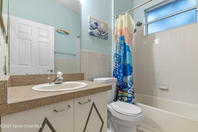 full bathroom featuring toilet, vanity, tile walls, and shower / bathtub combination with curtain