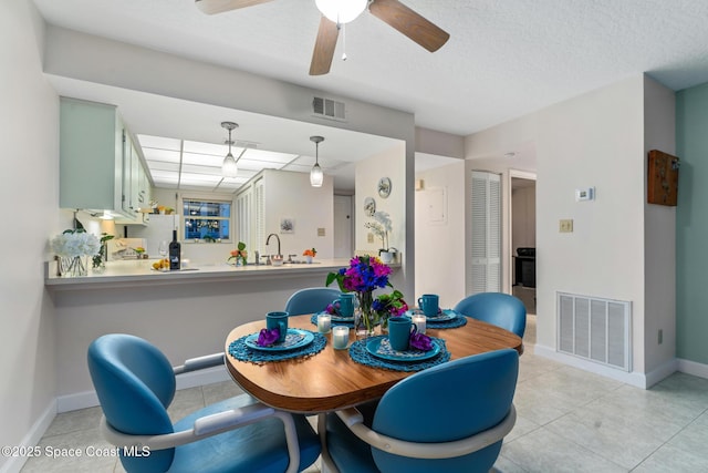 dining room with ceiling fan and a textured ceiling