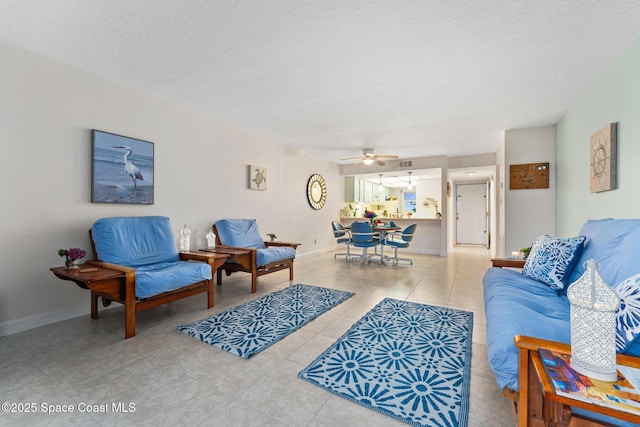 living room featuring ceiling fan and a textured ceiling