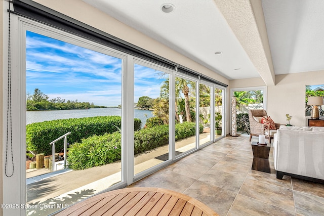 sunroom / solarium featuring a water view