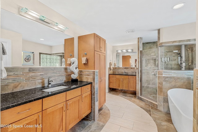 bathroom with vanity, tasteful backsplash, and independent shower and bath