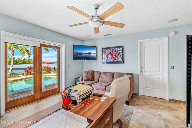 tiled living room with ceiling fan and a textured ceiling