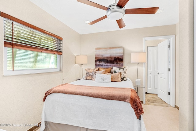 bedroom featuring light colored carpet and ceiling fan