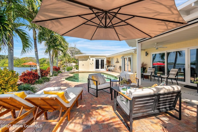 view of patio featuring an outdoor living space, french doors, ceiling fan, and a water view