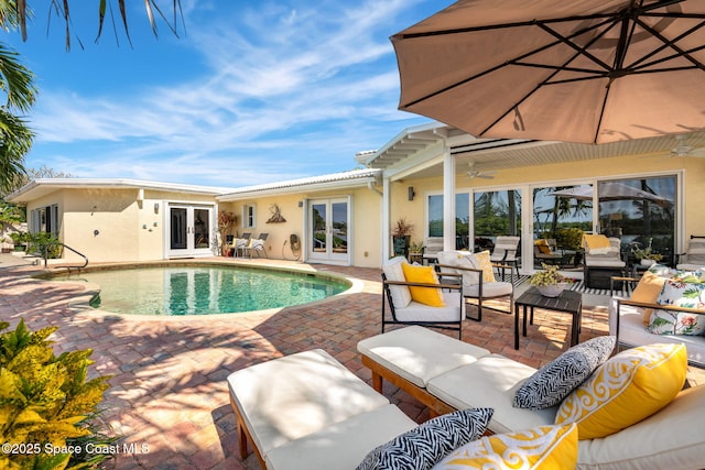 view of pool with a patio, outdoor lounge area, and french doors