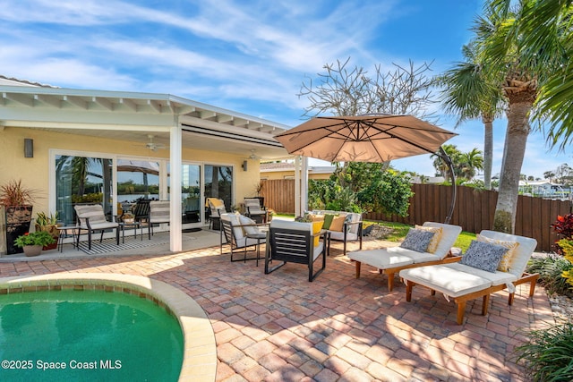 view of patio / terrace with an outdoor living space, a fenced in pool, and ceiling fan