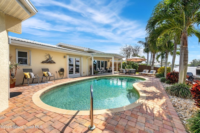 view of pool with french doors and a patio area