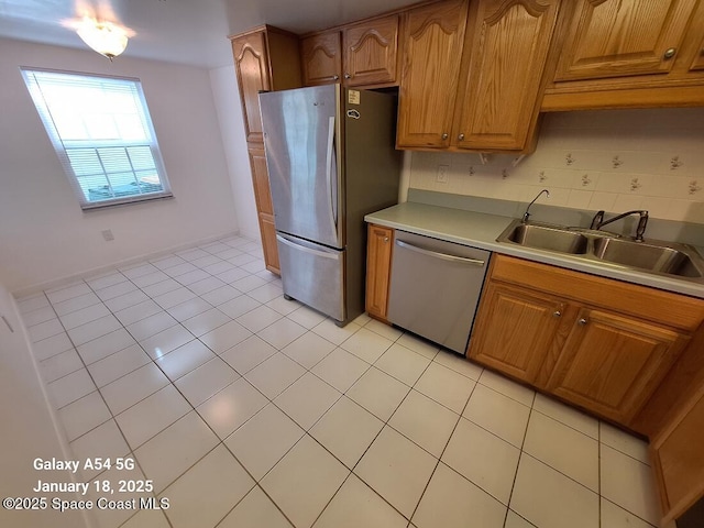 kitchen with sink, light tile patterned floors, backsplash, and appliances with stainless steel finishes