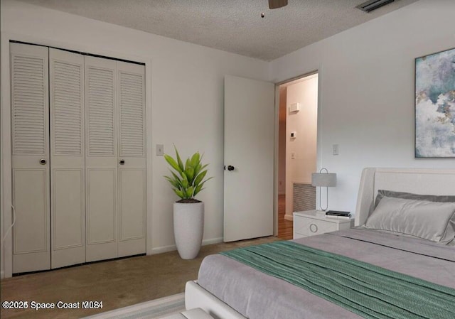 carpeted bedroom with a closet and a textured ceiling